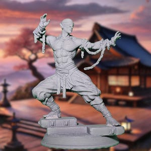 May include: A gray, detailed figurine of a blindfolded figure in a fighting pose. The figure is wearing a long-sleeved shirt and pants, and is bound with chains. The figure is standing on a gray base.