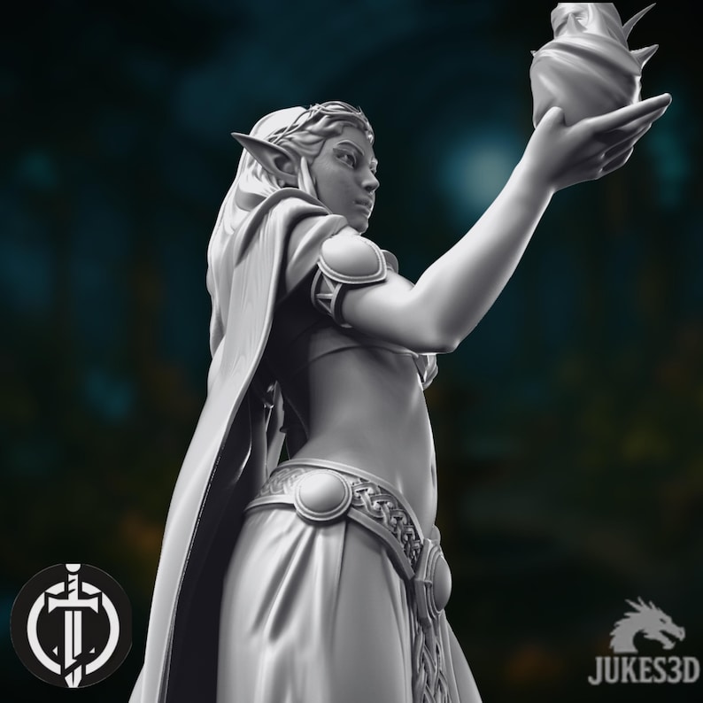 May include: A 3D-printed figurine of an elven woman, holding a decorative object. The figure is wearing a flowing gown and cape, with detailed belt and armbands. The image has a dark background. The JUKES3D logo is visible in the bottom right corner.