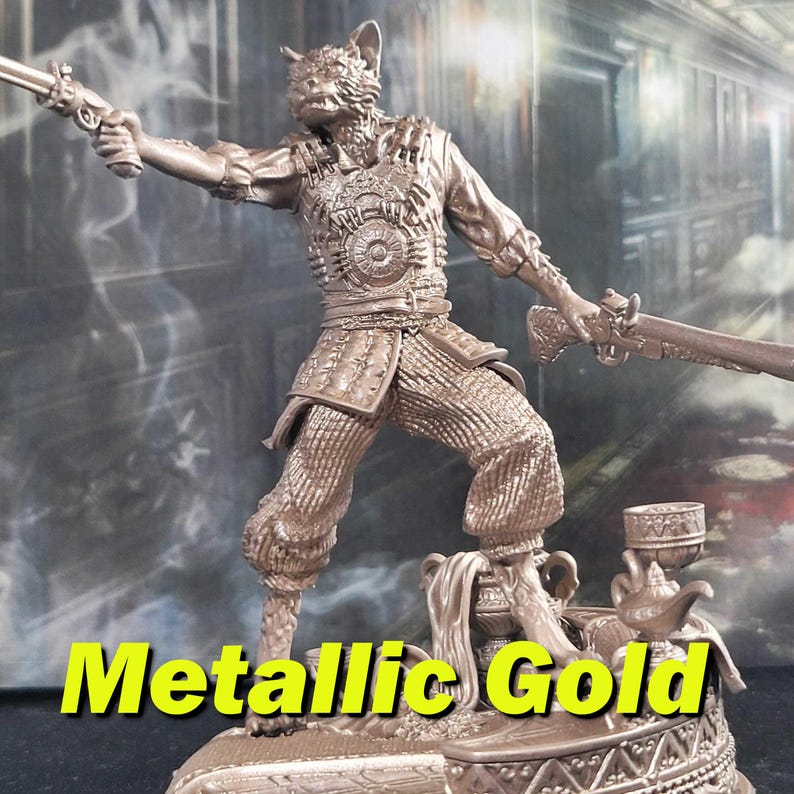May include: A metallic gold figurine of a cat-like creature holding a pistol in one hand and a sword in the other. The figurine is standing on a decorative base with a teapot and a cup.