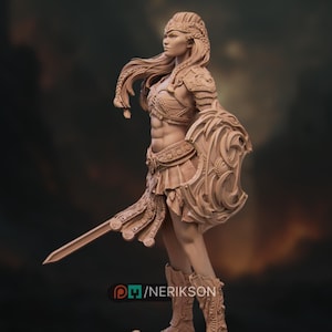 May include: A detailed figurine of a warrior woman, clad in armor and holding a sword and shield. The figure is in a dynamic pose, with intricate details in the armor, hair, and facial features. The shield has a decorative design. The figurine is a light brown color.