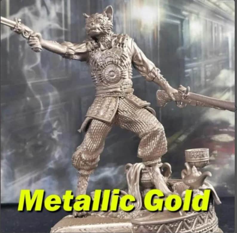 May include: Metallic gold figurine of a cat-like humanoid figure holding two antique firearms. The figure is wearing detailed armor and standing on a decorative base. The text "Metallic Gold" is displayed in a yellow font at the bottom of the image.