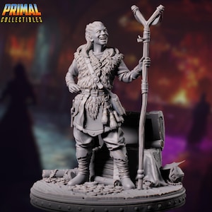 May include: A gray figurine of a smiling character with long hair, wearing a fur-lined vest, tunic, and boots, holding a staff. The figurine stands on a base with a treasure chest and coins. The logo "PRIMAL COLLECTIBLES" is in the top left corner.