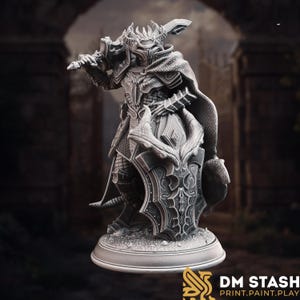 Puede incluir: Una detallada figura gris de un caballero con armadura completa, sosteniendo una gran espada y un escudo. El caballero tiene un casco con corona y una capa fluida. El escudo presenta un diseño ornamentado. La figura está sobre una base redonda. El logotipo "DM STASH PRINT.PAINT.PLAY" está en la parte inferior.