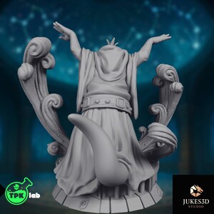 Rear view showing robed frog priest miniature with sculpted tail, sweeping decorative forms, layered cloth folds, and elaborate scenic base details.