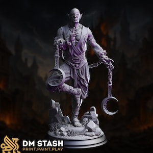 May include: A detailed 3D-printed figurine of a blindfolded figure, holding chains with crescent-shaped weights. The figure is standing on a rocky base. The figurine is in shades of purple and gray. The DM STASH logo is visible at the bottom.
