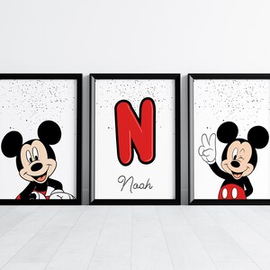 May include: Three framed prints featuring Mickey Mouse. One print shows Mickey smiling, another displays a red letter "N" with the name "Noah", and the third has Mickey giving a peace sign. All prints have a white background with black speckles.