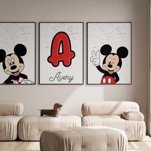 May include: Three framed prints featuring Mickey Mouse and a personalized design. One print shows Mickey Mouse smiling, another displays a red letter "A" with the name "Avery", and the third shows Mickey Mouse giving a peace sign.