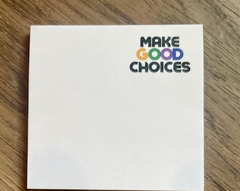 May include: White sticky note with the text "MAKE GOOD CHOICES" in black letters with a rainbow color scheme.
