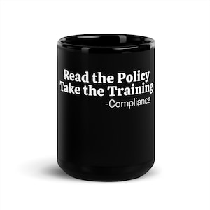 May include: A black ceramic mug featuring white printed text that reads Read the Policy Take the Training -Compliance. The mug has a cylindrical shape with a smooth finish and a standard handle, designed for holding hot or cold beverages.