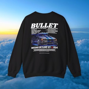 May include: Black sweatshirt with a graphic of a Nissan Skyline GT-R R34 car, featuring blue and white stripes. The word "BULLET" is above the car image, with engine and performance specs listed. The sweatshirt has a crew neck.