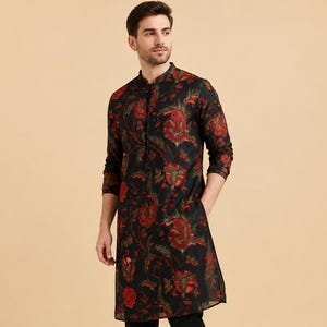 Può includere: Un kurta nero con stampa floreale, colletto alla coreana e maniche lunghe. Il kurta presenta un motivo floreale rosso ed è abbinato a pantaloni neri e mocassini neri.