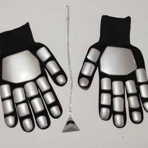 Peut inclure: Une paire de gants rembourrés noirs et argentés avec une chaîne argentée et un pendentif pyramide argenté.