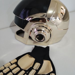 May include: A black and gold helmet with a visor and a pair of gold gloves. The helmet has a large, round shape and a black visor. The gloves are made of a soft, black material with gold accents.