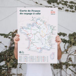 May include: A white poster with a map of France showing cycling routes. The poster has the title "Carte de France du voyage &agrave; v&eacute;lo" and a list of cycling routes.