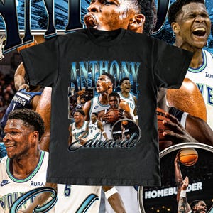 Peut inclure: T-shirt noir avec un collage du joueur de basket-ball Anthony Edwards. Le design comprend le nom "ANTHONY EDWARDS" dans une police stylisée, ainsi que des images du joueur en action. Le t-shirt a un aspect vintage et vieilli.