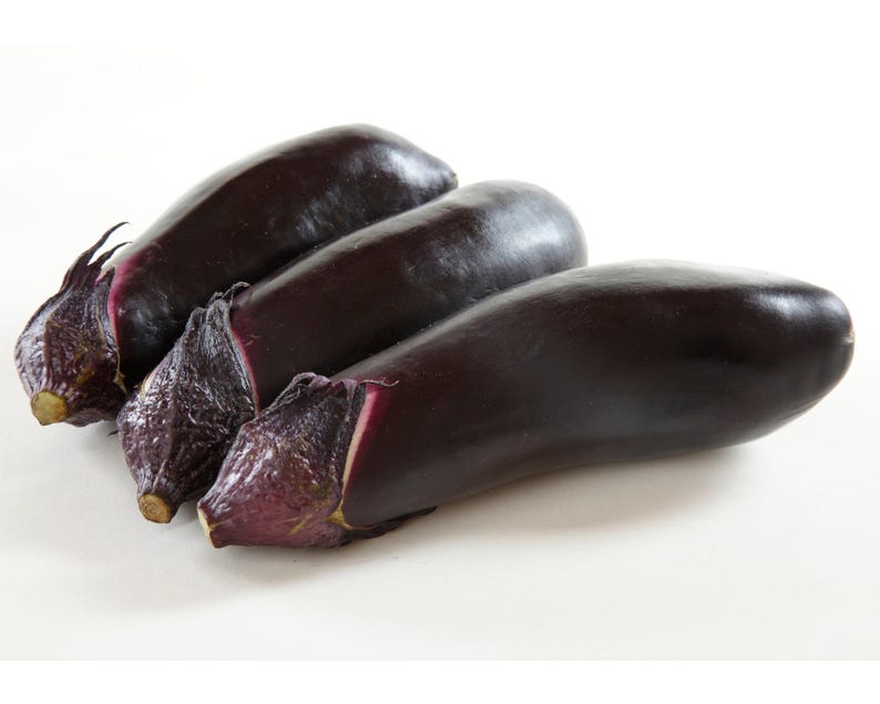 Pode incluir: Tr&ecirc;s berinjelas de cor roxa escura com um tom roxo ligeiramente mais claro na extremidade do caule.