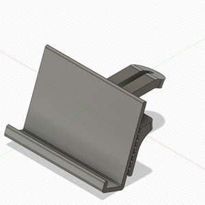 Puede incluir: Un soporte para teléfono de plástico gris con un clip en la parte posterior. El soporte está diseñado para sostener un teléfono en posición vertical.