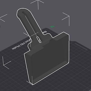 May include: A dark grey, 3D-rendered object with a handle and a rectangular base, outlined in white. The object is positioned on a dark grey surface with grid lines and white directional arrows. The design suggests a tool or component.
