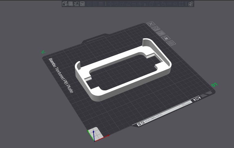 May include: A white plastic phone stand with a rectangular shape. The stand is designed to hold a phone upright. The stand is on a gray textured surface.