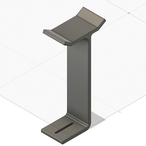 May include: A gray metal headphone stand with a rectangular base and a curved support. The top portion has a ledge to hold headphones. The stand is designed with a modern, minimalist aesthetic.
