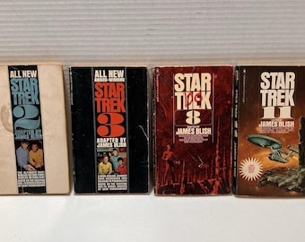 May include: Four vintage Star Trek books are shown, each with the series title and episode numbers on the covers. The books are in various colors, including beige, black, and red, with the author's name, James Blish, clearly visible.