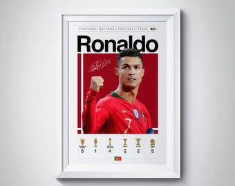 May include: A white framed poster with a red background featuring a photo of Cristiano Ronaldo in a red and green soccer jersey. The poster has the text "Ronaldo" in black and white letters and the text "PORTUGAL NATIONAL FOOTBALL TEAM" in smaller black letters. The poster also includes a signature and a row of five gold trophies with numbers indicating the number of wins.