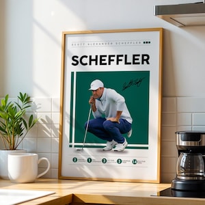 Puede incluir: Un póster enmarcado con el golfista Scottie Scheffler en posición agachada, listo para golpear. El póster tiene un fondo verde con el nombre "SCHEFFLER" en letras grandes y en negrita. Se puede ver una firma.