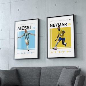 May include: Two framed posters of soccer players, Lionel Messi and Neymar Jr., with their jersey numbers, 10, and the text "MESSI" and "NEYMAR" in black on a white background. The posters are on a gray wall with a gray couch in front of them.