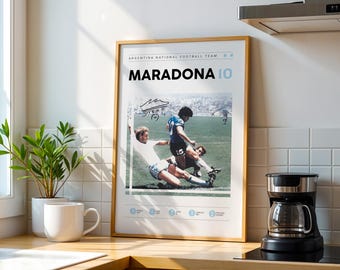 May include: A framed poster featuring a soccer action shot of Maradona in a blue jersey. The poster has the text "MARADONA 10" in large black letters, with the words "ARGENTINA NATIONAL FOOTBALL TEAM" above. The poster is in a light wood frame.
