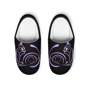 May include: A pair of black slippers with a purple stylized cat design. The cat is curled up in a circle with its tail wrapped around its body.