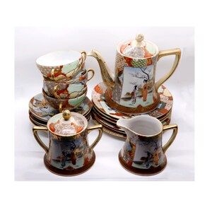 Peut inclure: Un service à thé japonais vintage comprenant une théière, une crémière, un sucrier, des tasses et des soucoupes. L'ensemble en porcelaine présente un design coloré avec des accents dorés. Les tasses et les soucoupes sont empilées.