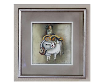 May include: Framed artwork featuring a stylized white bull with brown horns and yellow and blue accents. A small figure sits atop the bull. The artwork is in a silver frame.