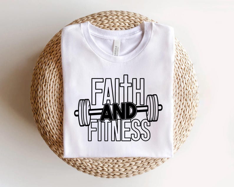 Może przedstawiać: Biała koszulka z czarnym napisem "Faith and Fitness" i grafiką hantle.