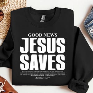 May include: Black sweatshirt with white text that reads "GOOD NEWS JESUS SAVES" and a Bible verse from John 3:16-17.