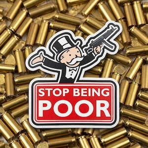 May include: A sticker featuring a cartoon character in a black tuxedo and top hat holding a black submachine gun, positioned above a red rectangular sign with white text that reads STOP BEING POOR, set against a background of brass bullet casings.