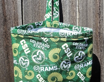 May include: A green and white fabric tote bag with a repeating pattern of the Colorado State Rams logo. The logo features a ram's head with the words "Colorado State Rams" and "CSU" written around it.