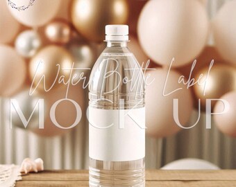Puede incluir: Una botella de agua de plástico transparente con una maqueta de etiqueta blanca. La botella está sobre una mesa de madera con un fondo borroso de globos de color melocotón y plata.
