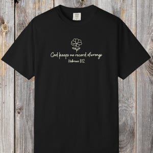 Camiseta con flores cristianas, Hebreos 8:12, Dios no guarda rencor, colores cómodos