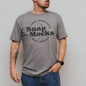 Könnte beinhalten: Ein heidefarbenes T-Shirt mit einem schwarzen Kreislogo, auf dem "Real Products, Snap Mocks, Real People" steht.