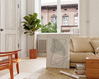 Puede incluir: Escena interior con una impresión artística abstracta enmarcada en tonos neutros. Se ven una gran planta en maceta y una silla de madera. La habitación tiene una combinación de colores neutros, con una ventana que da a un edificio.