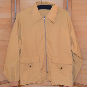May include: A tan zip-up jacket with two large pockets and a black knit collar.
