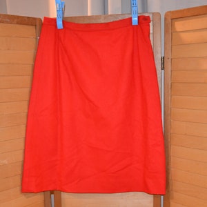 May include: A bright red knee-length skirt with a simple design.