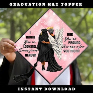 May include: A graduation hat topper with a pink and black design. The topper features an illustration of two figures in graduation gowns, one with angel wings. Text includes "I know you're looking down from heaven" and "And you're proud. This one's for you mom!"