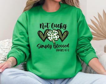 May include: Green sweatshirt with a black graphic that says "Not lucky simply blessed Romans 4:7-8" with a shamrock and two hearts.