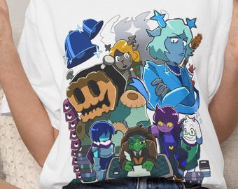 Puede incluir: Una camiseta blanca de manga corta con un estampado gráfico colorido de varios personajes animados, incluyendo una figura de pelo azul, un personaje parecido a una tortuga verde y una figura de piel oscura con pelo morado en un collage.