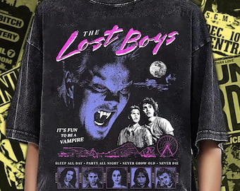 Puede incluir: Una camiseta negra con lavado ácido que presenta un estampado gráfico de la película The Lost Boys. El diseño incluye un rostro de vampiro, el texto The Lost Boys, It's fun to be a vampire, Sleep all day, Party all night, Never grow old, Never die y personajes.