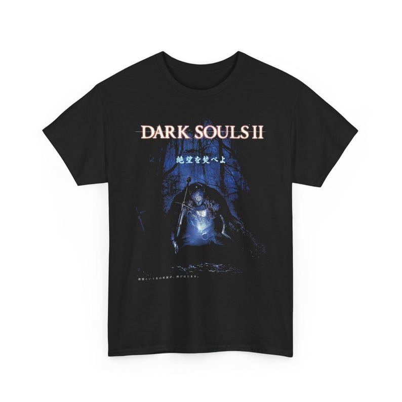 May include: Black t-shirt featuring the text "DARK SOULS II" above an illustration of a knight in a dark forest. The image has a blue and white color scheme, with Japanese text below the title.