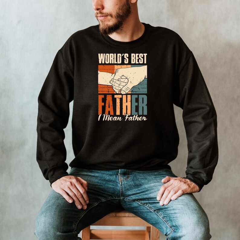May include: A black sweatshirt with a vintage-style graphic that says "World's Best Father I Mean Father" with a picture of two hands holding each other.