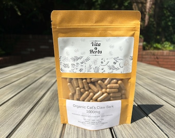 May include: A brown paper bag with a white label that says "Vita & Herbs" and "Organic Cat's Claw Bark 1000mg". The bag contains a large number of brown capsules.
