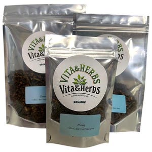 May include: Three silver pouches of Vita & Herbs organic clove. Each pouch has a round label with the brand name and a blue label with the product name and weight. The cloves are dark brown.